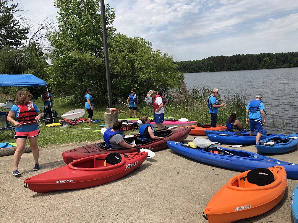 A group of kayak volunteers are preparing to go out on the lake.